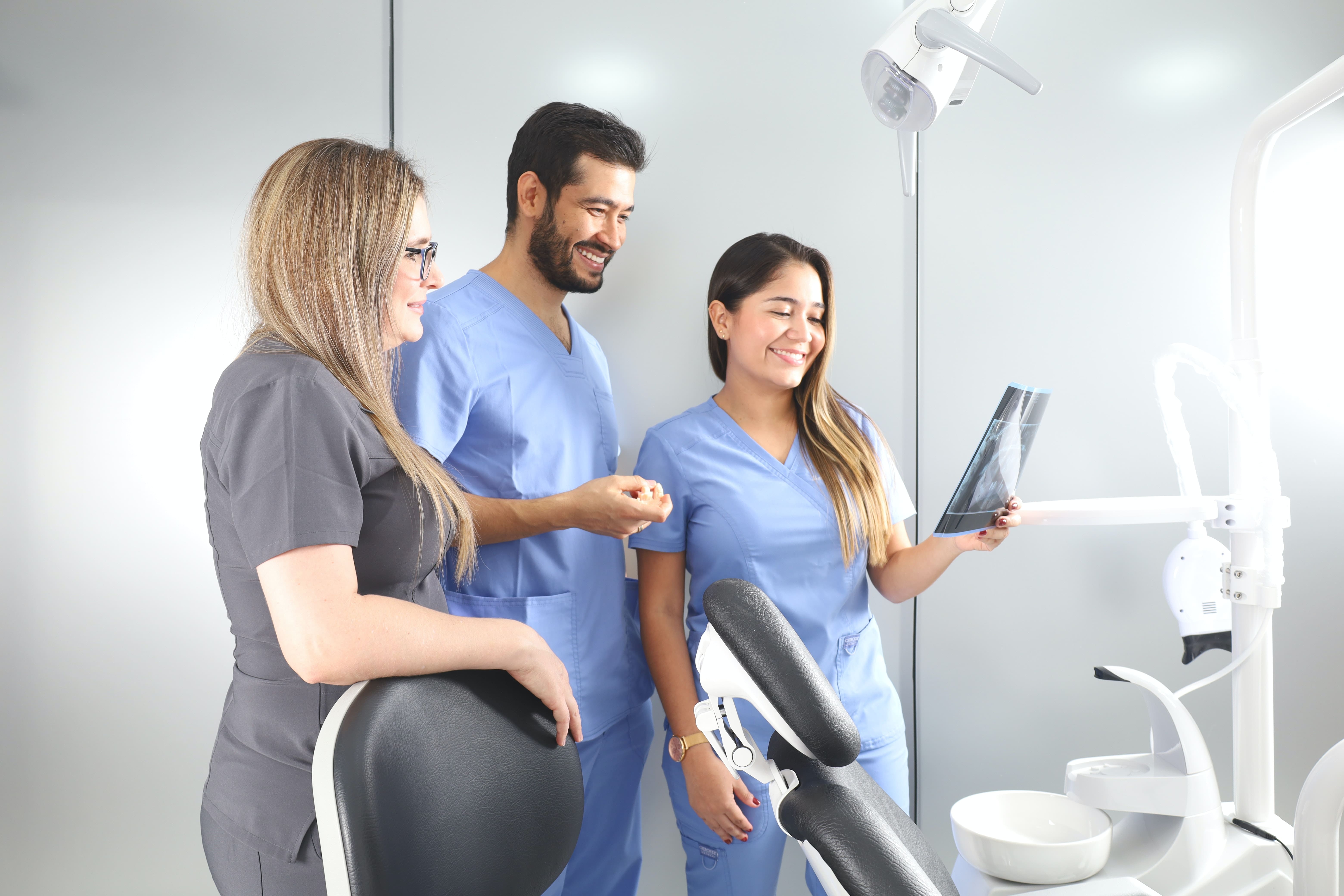diş kliniğinde yapay zeka görüntüleme ile 2 kadın ve bir erkek tanı sonuçlarına bakıyor