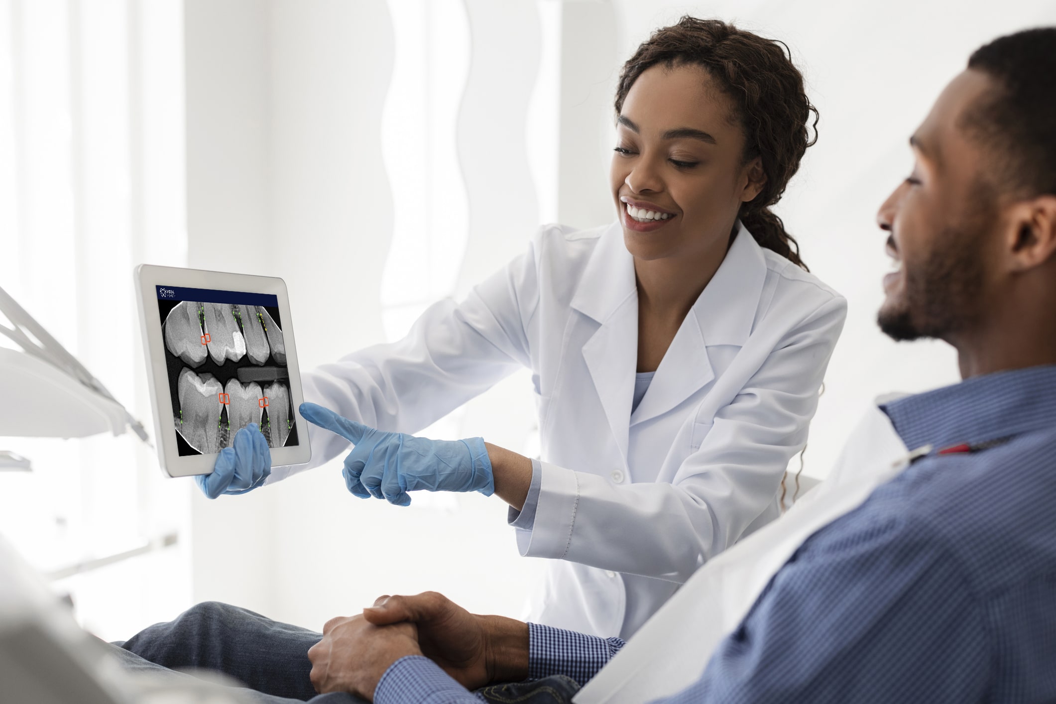 dentist shows dental x-ray to patient after analyzing it